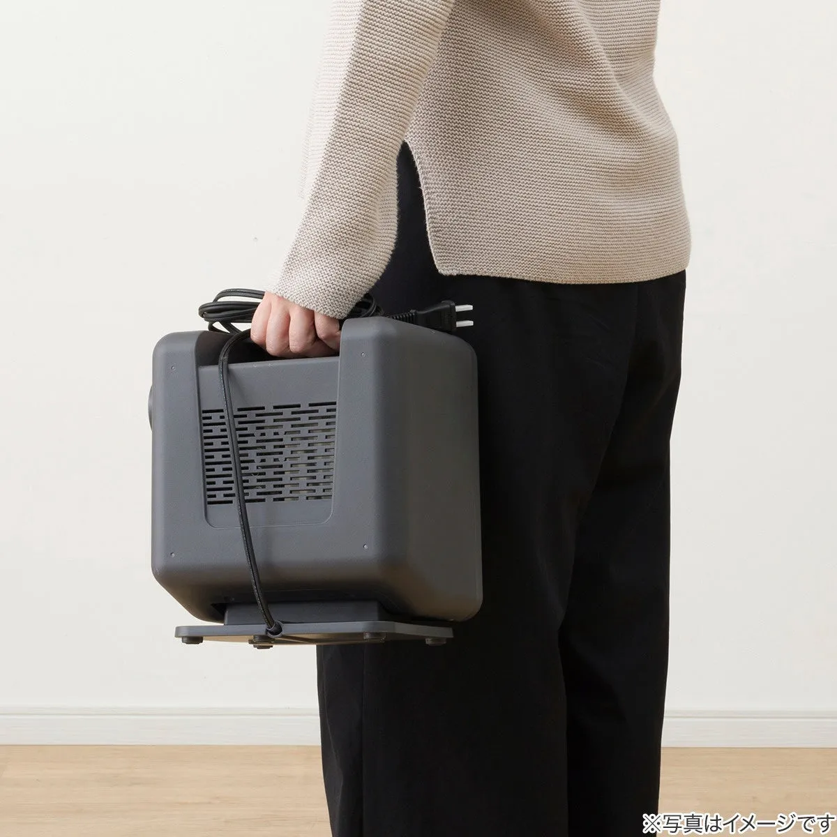 人が暖房器具を持ち運んでいる様子が写っています。